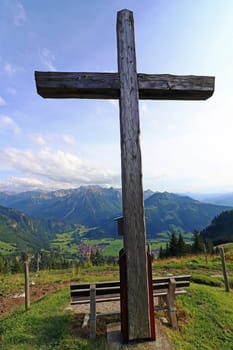 A summit cross in the Alps. A summit cross in the Allgaeu Alps. A summit cross in the evening light against the sky.