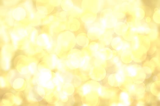 A festive abstract delicate golden yellow gradient background texture with glitter defocused sparkle bokeh circles. Card concept for Happy New Year, party invitation, valentine or other holidays.