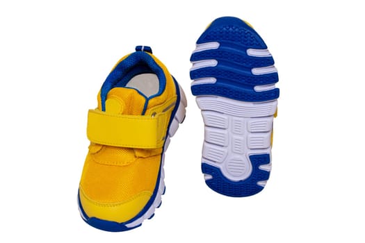 Child shoe fashion. Close-up of a pair of yellow blue child sneaker or sport shoes isolated on a white background. Elegant and trendy shoes for girls. Macro.