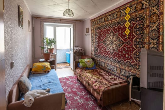 Volgograd, Russia - August 30, 2019: The interior of the bedroom with an outdated interior with access to a glazed balcony