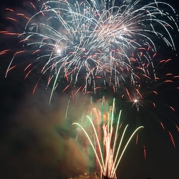 Red colorful holiday fireworks on the black sky background.