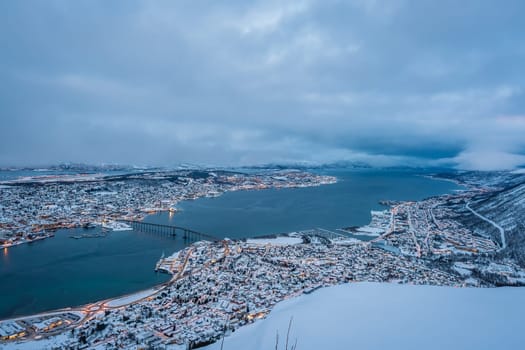 Aerial view to the city of Tromso in winter from the mountain ledge Storsteinen, 421 m above sea level , Northern Norway