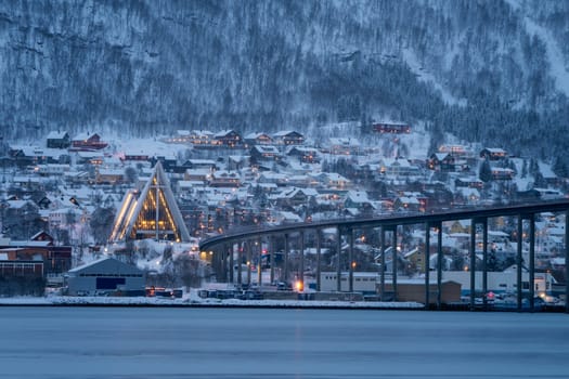 Arctic Cathedral with famous Tromso Bridge across Tromsoysundet strait in the background, Northern Norway
