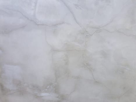 Abstract surface off smooth, grey plaster wall with cracks and scratches. Old grungy, weathered construction structure, dirty texture.