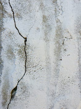 Old grungy, weathered concrete wall with big cracks. White beton structure, abstract details of construction element. Dirty texture surface.