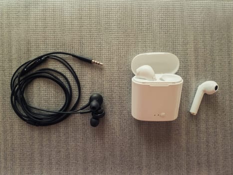 Comparison between 3.5mm jack wired headphones vs wireless earphones for music listening. Pros and cons, opposite contrary. Technology development tendencies, human entertainment conveniences concept.