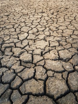 Dry and broken clay ground during drought season, concept of global warming problem. Cracked and barren soil texture background. The global shortage of water on the planet. Arid land, natural disaster