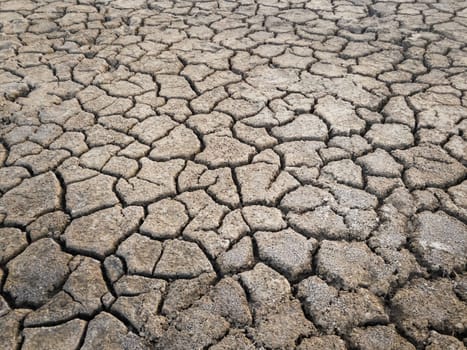 Dry and broken clay ground during drought season, concept of global warming problem. Cracked and barren soil texture background. The global shortage of water on the planet. Arid land, natural disaster
