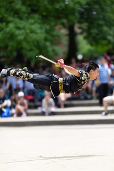 Columbus, Ohio, USA - May 26, 2019: Columbus Asian Festival, Franklin Park, Man wearing traditional chinese clothing handling a Kungfu broadsword during the festival
