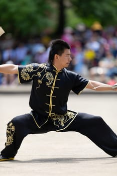 Columbus, Ohio, USA - May 26, 2019: Columbus Asian Festival, Franklin Park, Man using double Duilian Broadswords, fighting two men with Sticks