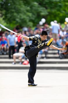 Columbus, Ohio, USA - May 26, 2019: Columbus Asian Festival, Franklin Park, Man wearing traditional chinese clothing handling a Kungfu broadsword during the festival