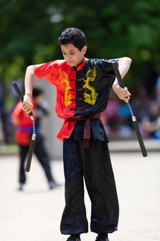 Columbus, Ohio, USA - May 26, 2019: Columbus Asian Festival, Franklin Park, Boy using Nunchakus, wearing traditional clothing