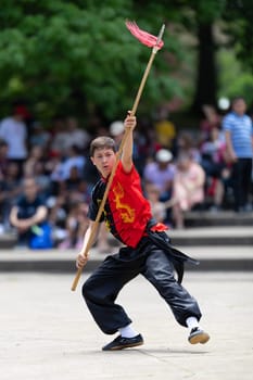 Columbus, Ohio, USA - May 26, 2019: Columbus Asian Festival, Franklin Park, Boy wearing traditional chinese clothing handling a Kung Fu Spear.