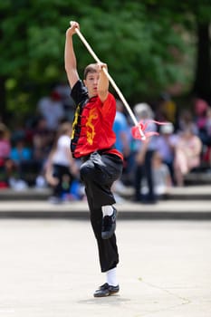 Columbus, Ohio, USA - May 26, 2019: Columbus Asian Festival, Franklin Park, Boy wearing traditional chinese clothing handling a Kung Fu Spear.