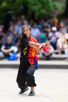 Columbus, Ohio, USA - May 26, 2019: Columbus Asian Festival, Franklin Park, woman wearing traditional chinese clothing handling a Kungfu broadsword during the festival