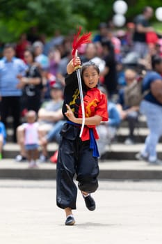 Columbus, Ohio, USA - May 26, 2019: Columbus Asian Festival, Franklin Park, woman wearing traditional chinese clothing handling a Kungfu broadsword during the festival