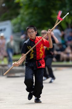 Columbus, Ohio, USA - May 26, 2019: Columbus Asian Festival, Franklin Park, Boy wearing traditional chinese clothing handling a Kung Fu Spear.