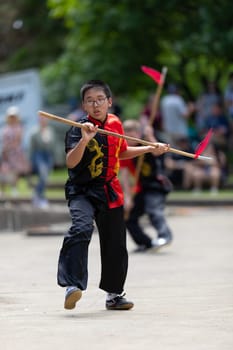 Columbus, Ohio, USA - May 26, 2019: Columbus Asian Festival, Franklin Park, Boy wearing traditional chinese clothing handling a Kung Fu Spear.