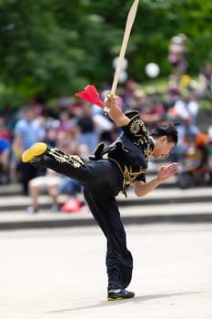 Columbus, Ohio, USA - May 26, 2019: Columbus Asian Festival, Franklin Park, Man wearing traditional chinese clothing handling a Kungfu broadsword during the festival