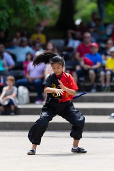 Columbus, Ohio, USA - May 26, 2019: Columbus Asian Festival, Franklin Park, young woman wearing traditional chinese clothing performing a display from Wushu Academy martial arts