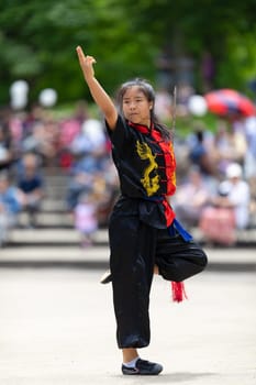 Columbus, Ohio, USA - May 26, 2019: Columbus Asian Festival, Franklin Park, woman wearing traditional chinese clothing handling a Kungfu broadsword during the festival