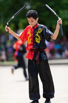 Columbus, Ohio, USA - May 26, 2019: Columbus Asian Festival, Franklin Park, Boy using Nunchakus, wearing traditional clothing