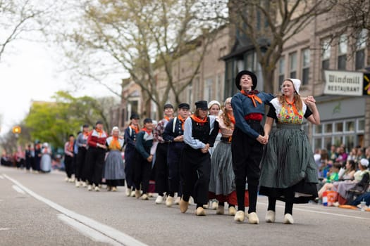 Holland, Michigan, USA - May 11, 2019: Tulip Time Festival, Young women wearing traditional Dutch Clothing dancing in the streets of Holland, Michigan during the Festival