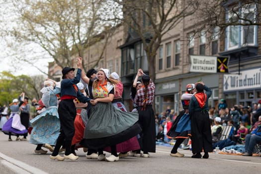Holland, Michigan, USA - May 11, 2019: Tulip Time Festival, Young women wearing traditional Dutch Clothing dancing in the streets of Holland, Michigan during the Festival