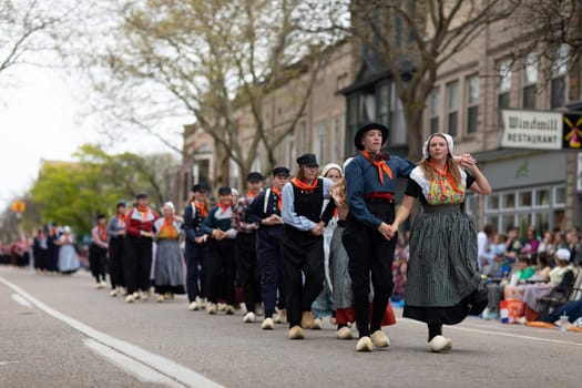 Holland, Michigan, USA - May 11, 2019: Tulip Time Festival, Young women wearing traditional Dutch Clothing dancing in the streets of Holland, Michigan during the Festival