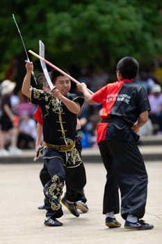 Columbus, Ohio, USA - May 26, 2019: Columbus Asian Festival, Franklin Park, Man using double Duilian Broadswords, fighting two men with Sticks
