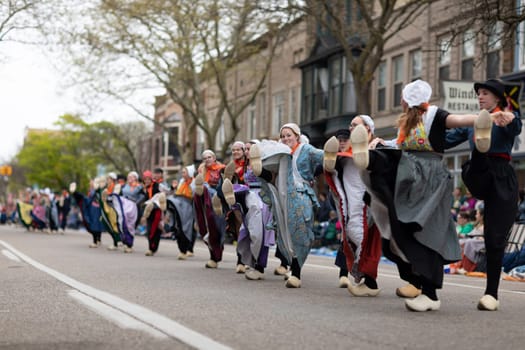 Holland, Michigan, USA - May 11, 2019: Tulip Time Festival, Young women wearing traditional Dutch Clothing dancing in the streets of Holland, Michigan during the Festival