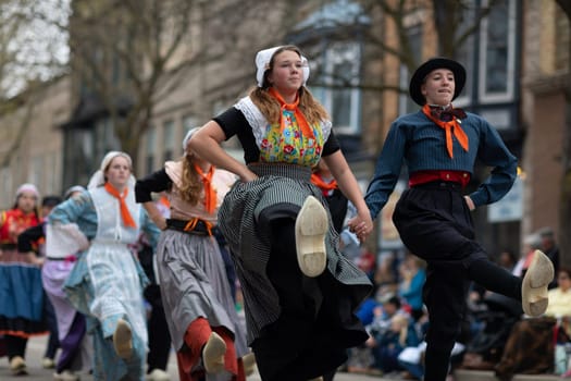 Holland, Michigan, USA - May 11, 2019: Tulip Time Festival, Young women wearing traditional Dutch Clothing dancing in the streets of Holland, Michigan during the Festival