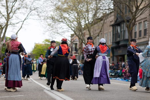Holland, Michigan, USA - May 11, 2019: Tulip Time Festival, Young women wearing traditional Dutch Clothing dancing in the streets of Holland, Michigan during the Festival