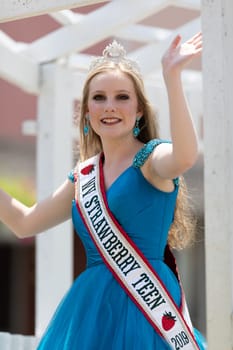 Buckhannon, West Virginia, USA - May 18, 2019: Strawberry Festival, WV Srawberry Teen, on a float, smiling and waving at spectators
