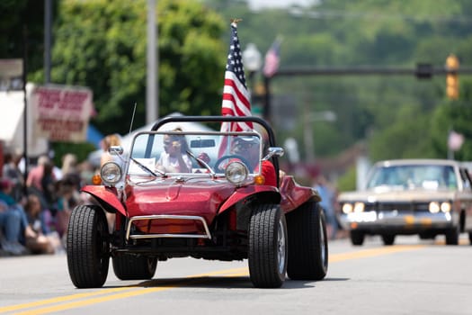 Buckhannon, West Virginia, USA - May 18, 2019: Strawberry Festival, Buggie carrying the American Flag, being driven by a man going down main street during the parade