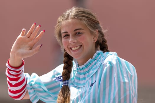 Buckhannon, West Virginia, USA - May 18, 2019: Strawberry Festival, Young woman wearing American traditional clothing waving and smiling for the camera