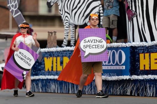 Louisville, Kentucky, USA - May 2, 2019: The Pegasus Parade, People holding signs promoting nature conservation during the parade