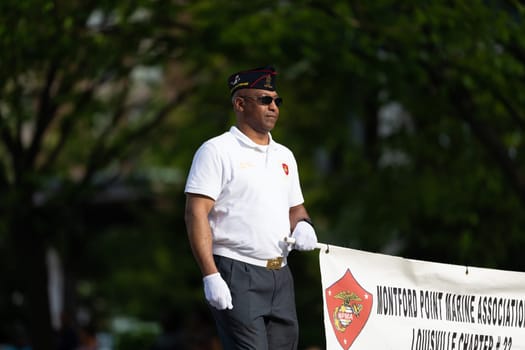 Louisville, Kentucky, USA - May 2, 2019: The Pegasus Parade, Man carrying a banner promoting Montford Marine Association during the parade