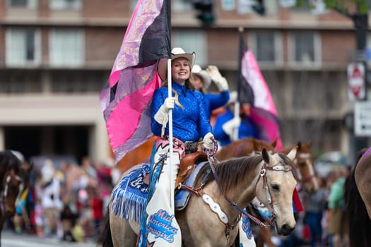 Louisville, Kentucky, USA - May 2, 2019: The Pegasus Parade, The Mid America Cowgirls riding horses and carrying flags during the parade