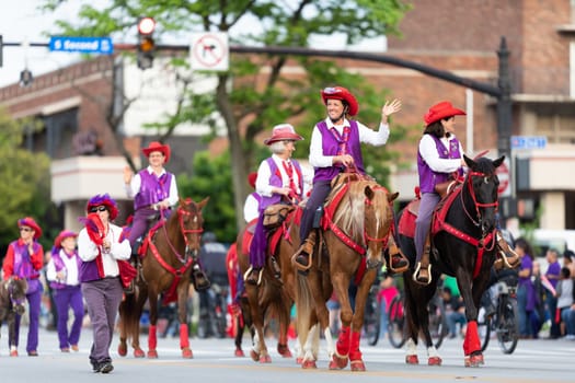 Louisville, Kentucky, USA - May 2, 2019: The Pegasus Parade, Members of the Red Hats & Purple Chaps, riding horses, during the parade