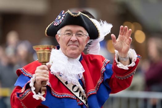 Holland, Michigan, USA - May 11, 2019: Tulip Time Parade, Man wearing traditional dutch clothing, handling a bell and waving at people during the parade