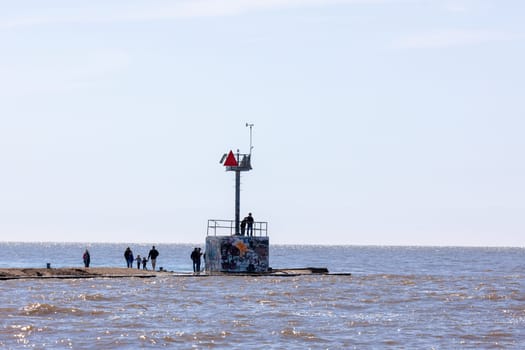 St. Joseph, Michigan, USA - May 4, 2019: View of people walking on the pier with a small lighthouse at lake michigan