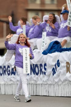 Louisville, Kentucky, USA - May 2, 2019: The Pegasus Parade, woman holding a sign that says, living donor, promoting organ donation during the parade