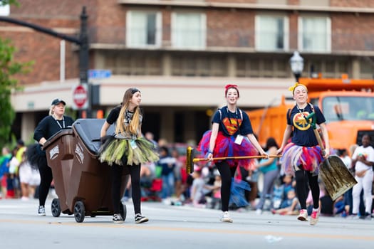 Louisville, Kentucky, USA - May 2, 2019: The Pegasus Parade, Young women keeping the streets free of horses poop during the parade