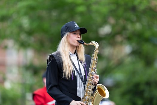 Louisville, Kentucky, USA - May 2, 2019: The Pegasus Parade, Young woman member of the All-Star Band, playing the saxophone during the parade