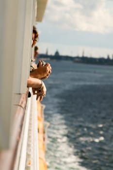 Beginning of a cruise. Hands of passengers.