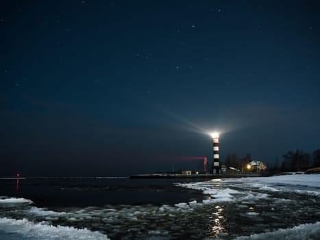 Riga Lighthouse in a starry night with frozen Baltic sea