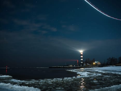Riga Lighthouse in a starry night with frozen Baltic sea