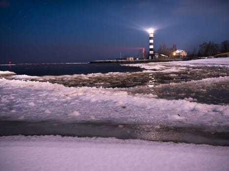 Riga Lighthouse in a starry night with frozen Baltic sea