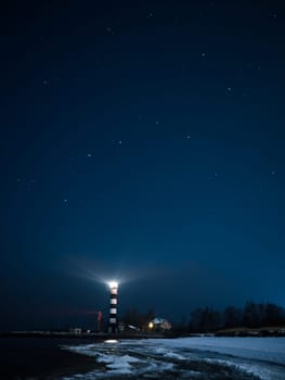 Riga Lighthouse in a starry night with frozen Baltic sea